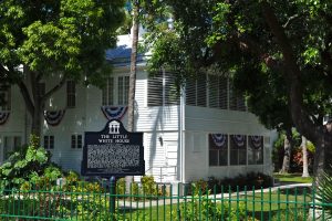 Outside the gates of the Truman Little White House in Key West, Florida where we see a placard in the yard denoting the property as historically relevant