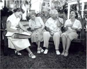 President Truman sitting on a bench with three women
