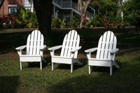 Three, white Adirondack chairs on the lawn of the Truman Little White House, Key West, Florida